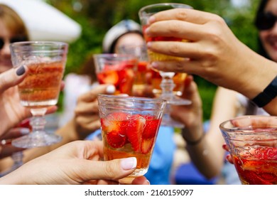 Friends clinking glasses with cocktails on summer weekend day. Picknick - Shutterstock ID 2160159097