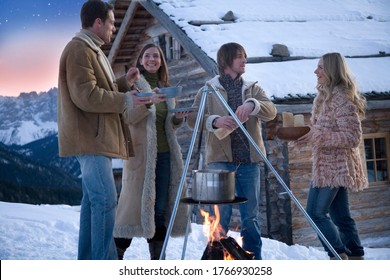 Friends Cooking On Outdoor Fire In Winter