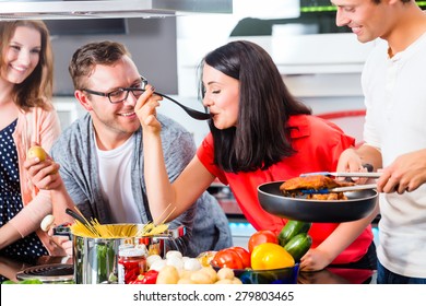 Friends cooking spaghetti and meat in domestic kitchen - Powered by Shutterstock