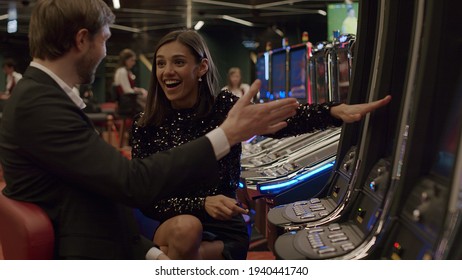 Friends Or Couple Enjoying Playing The Slot Machine At The Elite Casino. Gambling, Nightlife