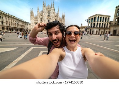 friends couple taking a selfie in front of a famous landmark - Tourists photographing the Duomo cathedral in Milan - happy tourist people on vacation sightseeing the city Milano - Shutterstock ID 1994150330