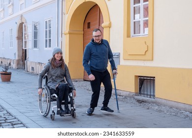 Amigos con discapacidad. Mujer en silla de ruedas y hombre con bastón