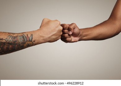 Friends do a fist bump close up isolated on white