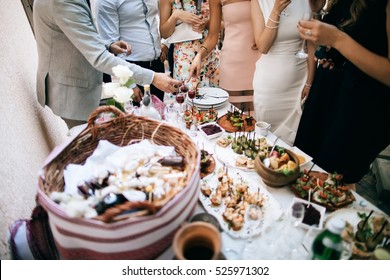 friends drink alcohol and eat snacks and talk at the celebration of the wedding