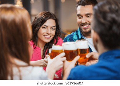 Friends Drinking Beer And Clinking Glasses At Pub