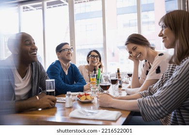 Friends drinking beer and wine at bistro table - Powered by Shutterstock