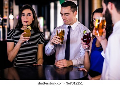 Friends drinking cocktails and beers in a bar