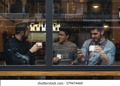 Friends drinking coffee and chatting in cafe. - Powered by Shutterstock