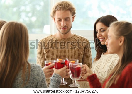 Friends drinking delicious mulled wine at party