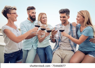 Friends Drinking Red Wine On The Summer Terrace.