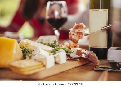 Friends Drinking Wine And Eating Cheese