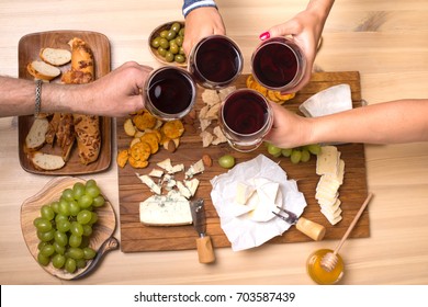 Friends Eating Cheese With Grapes And Drinking Wine At Home Together, Cheese Party Concept.