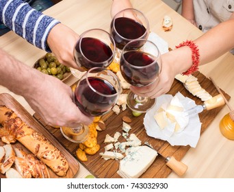 Friends Eating Cheese With Grapes And Drinking Wine At Home Together, Cheese Party Concept.