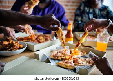 Friends eating pizza together at home