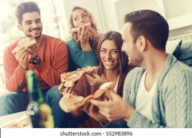 Friends eating pizza.They are having party at home, eating pizza and having fun. - Powered by Shutterstock