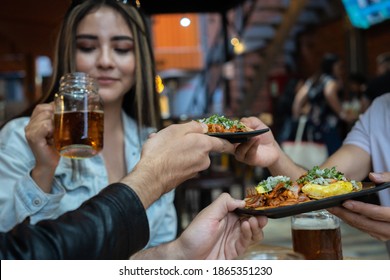 Friends Eating And Sharing Pastor Tacos In A Restaurant