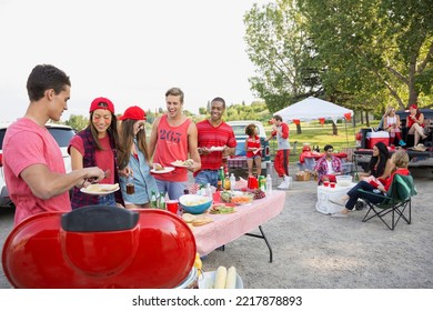 Friends eating at tailgate barbecue in field