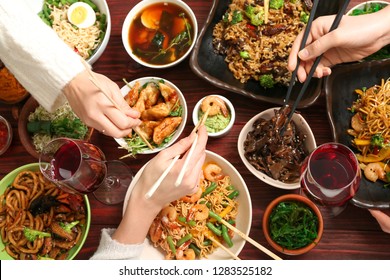 Friends Eating Tasty Chinese Food At Table