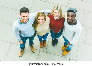 Friends Embraced And Looking At Camera, Aerial View. Mixed Race Group Of Best Friends In London, Over Head Image With People Looking Up. Friendship And Teamwork Concepts.