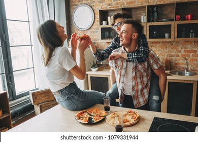 Friends Enjoy Eating And Togetherness. Group Of Young People Laughing, Eating And Sharing Time Together. Party, Community, Togetherness, Friendship Concept