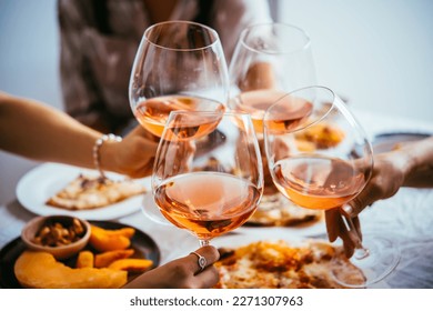 Friends enjoy a home rose wine party with pizza. - Shutterstock ID 2271307963