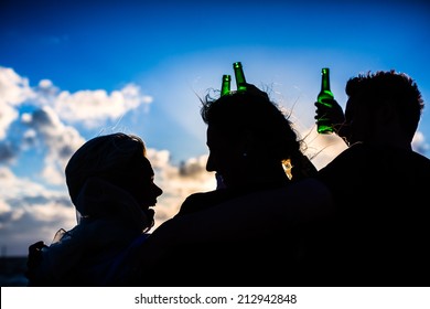 Friends Enjoying Bottled Beer At Sunset On German North Sea Beach 