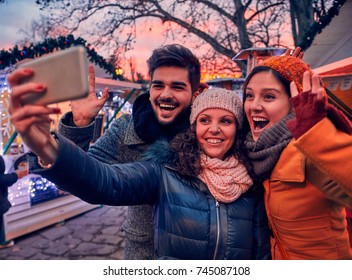 Friends Enjoying Christmas Market And Making Selfie