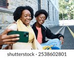 Friends Enjoying a Joyful Outdoor Moment in the City While Taking a Fun Selfie Together on the Street