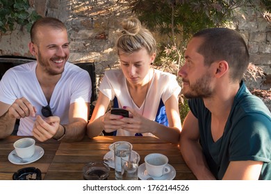 Amigos disfrutando del café matutino y nocturno en una cafetería y usando un moderno smartphone.
