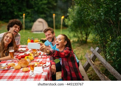 Friends Enjoying Picnic Day And Making Selfie Together.