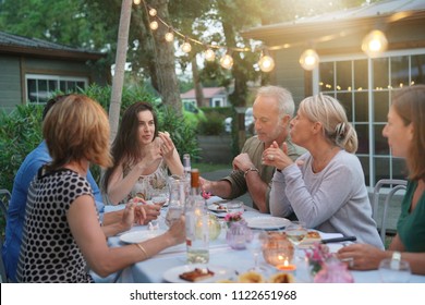 Friends Enjoying Summer Barbecue Dinner In Garden