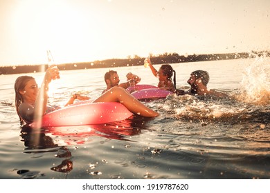 Friends Enjoying A Summer Day Swimming At The Lake.	