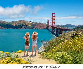 Friends enjoying time together on vacation  trip.  Girls looking at beautiful view of Golden Gate Bridge, over Pacific Ocean. San Francisco, California, USA - Powered by Shutterstock