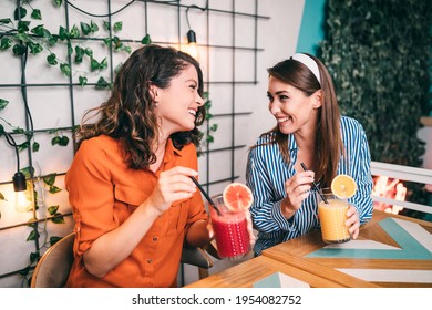 Friends enjoying together in restaurant. They are drinking a fresh beetroot and orange juice. - Powered by Shutterstock