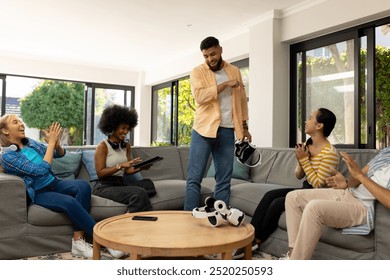 Friends enjoying VR gaming together, laughing and having fun in living room. technology, entertainment, bonding, virtual reality - Powered by Shutterstock