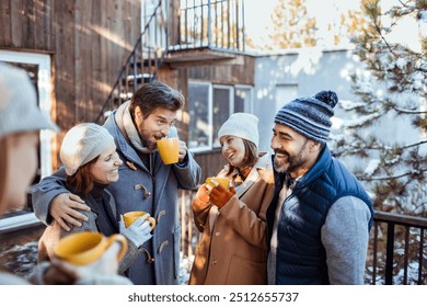 Friends enjoying warm drinks outside during a winter gathering - Powered by Shutterstock