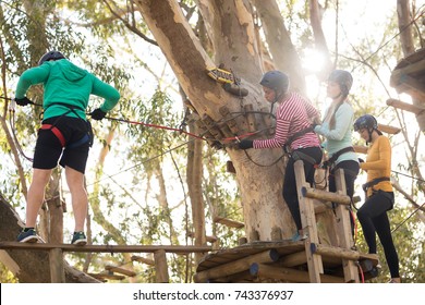 Friends enjoying zip line adventure in park on a sunny day - Shutterstock ID 743376937
