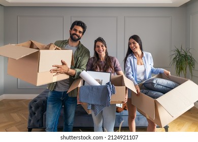 Friends excited becoming roommates moving in in their new apartment carrying cardboard boxes with their personal belongings. - Shutterstock ID 2124921107
