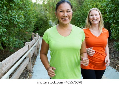 Friends Exercising And Walking Outside Together.  Women Getting Fit.