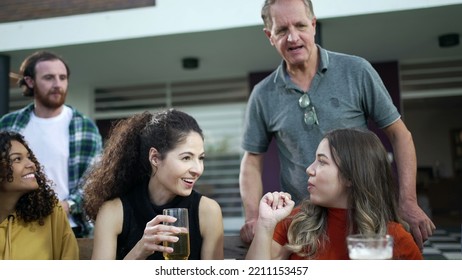 Friends And Family Gathered Together For Barbecue In Home Backyard Party. People Celebrating Life Toasting With Drinks