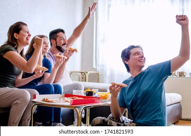 Friends And Family Watching Championship At Home Together.Fans Eating Pizza And Cheering For Their Sports Club With Hands Up.Happy Group Of People Watching Tv Show Or Sport Event.