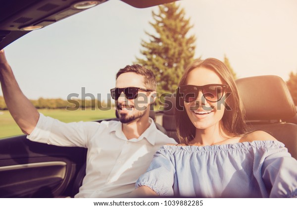 Friends, friendship, destination, rent, escape,\
speed ride, dreams, happiness lifestyle. Close up shot family\
portrait in a vehicle, carefree wife driver and henpecked husband\
on way to honeymoon