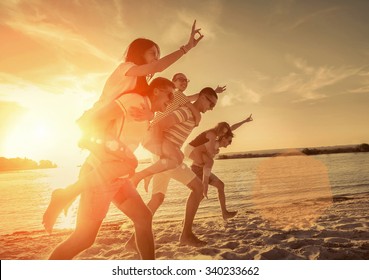 Friends fun on the beach under sunset sunlight. - Powered by Shutterstock