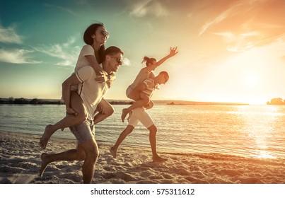 Friends fun on the beach under sunset sky with clouds at sunny day. - Shutterstock ID 575311612