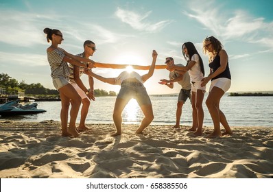 Friends funny game on the beach under sunny sky with clouds at summer day. - Powered by Shutterstock