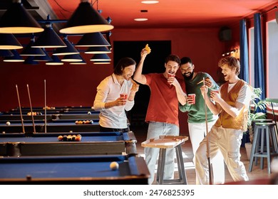 Friends are gathered around a pool table, laughing and enjoying a casual game of billiards in a bar setting.