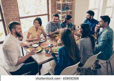 Friend`s gathering for feast. Cheerful youth is having tasty food and wine at the indoor party. So many emotions and memories to share! - Powered by Shutterstock