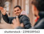 friends greeting each other on the street with their hands