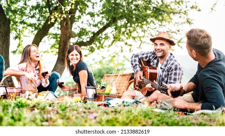 Friends Group Having Fun Moment At Pic Nic Playing Guitar On Sunset - Friendship Life Style Concept With Young People Enjoying Springtime Camping Together At Park Location - Bright Greenish Filter