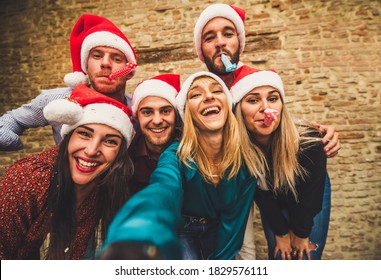 Friends group with santa hats celebrating Christmas taking a selfie - Winter holidays concept with people enjoying time and having fun together - Powered by Shutterstock